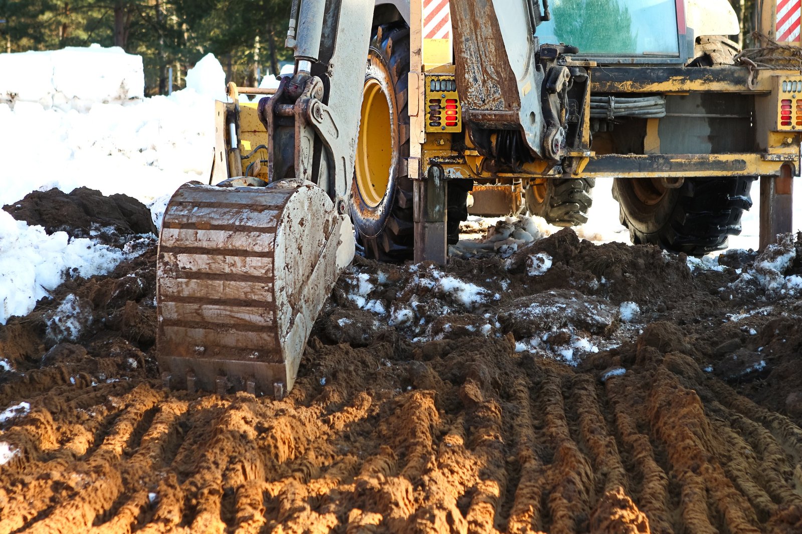 Bulldozer bucket close-up digs a pit for the construction. The foundation of the house, earthworks.